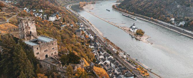 Vedere panoramică a râului Dunărea înconjurat de dealuri și orașe, în timpul toamnei cu frunze color.