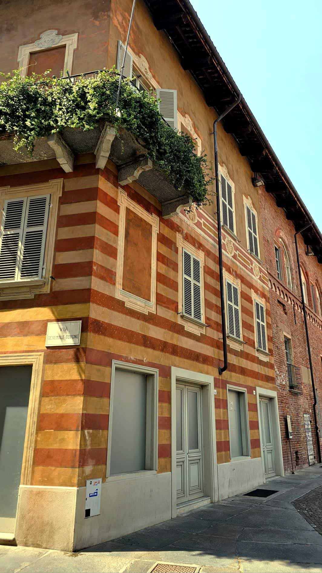 Clădire istorică cu fațadă colorată și balcon cu flori, în centrul orașului, reprezentând arhitectur.