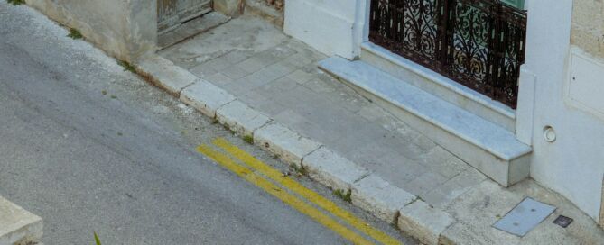 Clădire tradițională malteză cu ușă verde și balustradă neagră.